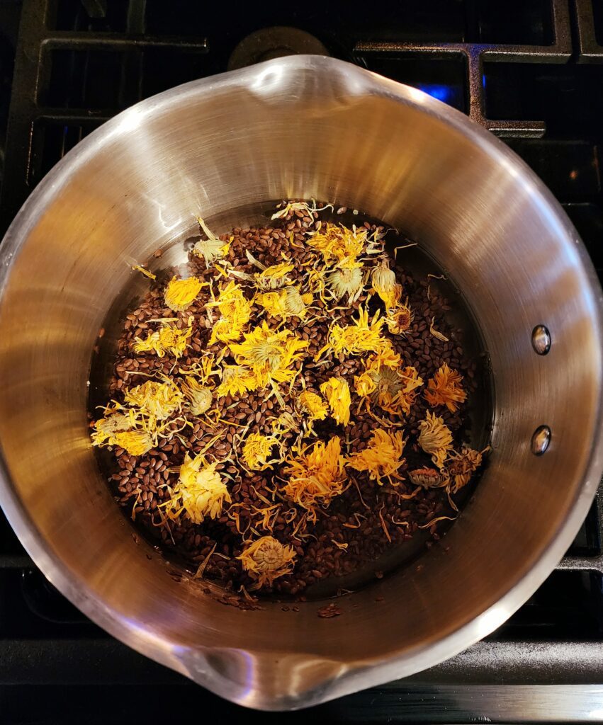 Pot of water on stove with flaxseed and calendula